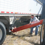 Tester, the farmer, negotiates with a grain auger at his Montana farm.