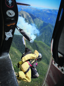 A Missoula Smokejumper exits a Douglas DC3 aircraft to respond to rapidly growing wildland fire just west of Paradise Valley with the Absaroka-Beartooth wilderness in the background. PHOTO BY JON MARSHALL