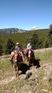 Finley and Grayson horseback riding at Lone Mountain Ranch, with Big Sky Resort's Lone Mountain in the background.