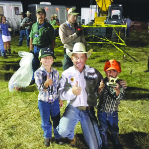 Brothers Max and Will Lynch of Jackson, Wyo. take a photo with former professional bull rider Cord McCoy. 