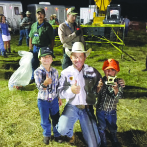Brothers Max and Will Lynch of Jackson, Wyo. take a photo with former professional bull rider Cord McCoy.