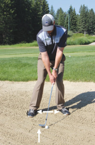 The guru digs in his golf shoes to demonstrate the essentials of a bunker shot: firm footing, a wider stance for longer shots, and where he’ll address the ball – 2-4 inches behind his lie. PHOTO BY TYLER ALLEN