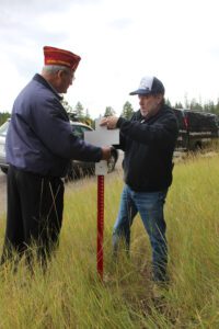 Local Big Sky Post 99 Commander Kenny Alley (at right) assists Commander Barnett in the white cross dedication for Kelsey McLean, who was killed in an Aug. 17 vehicle accident on Lone Mountain Trail.