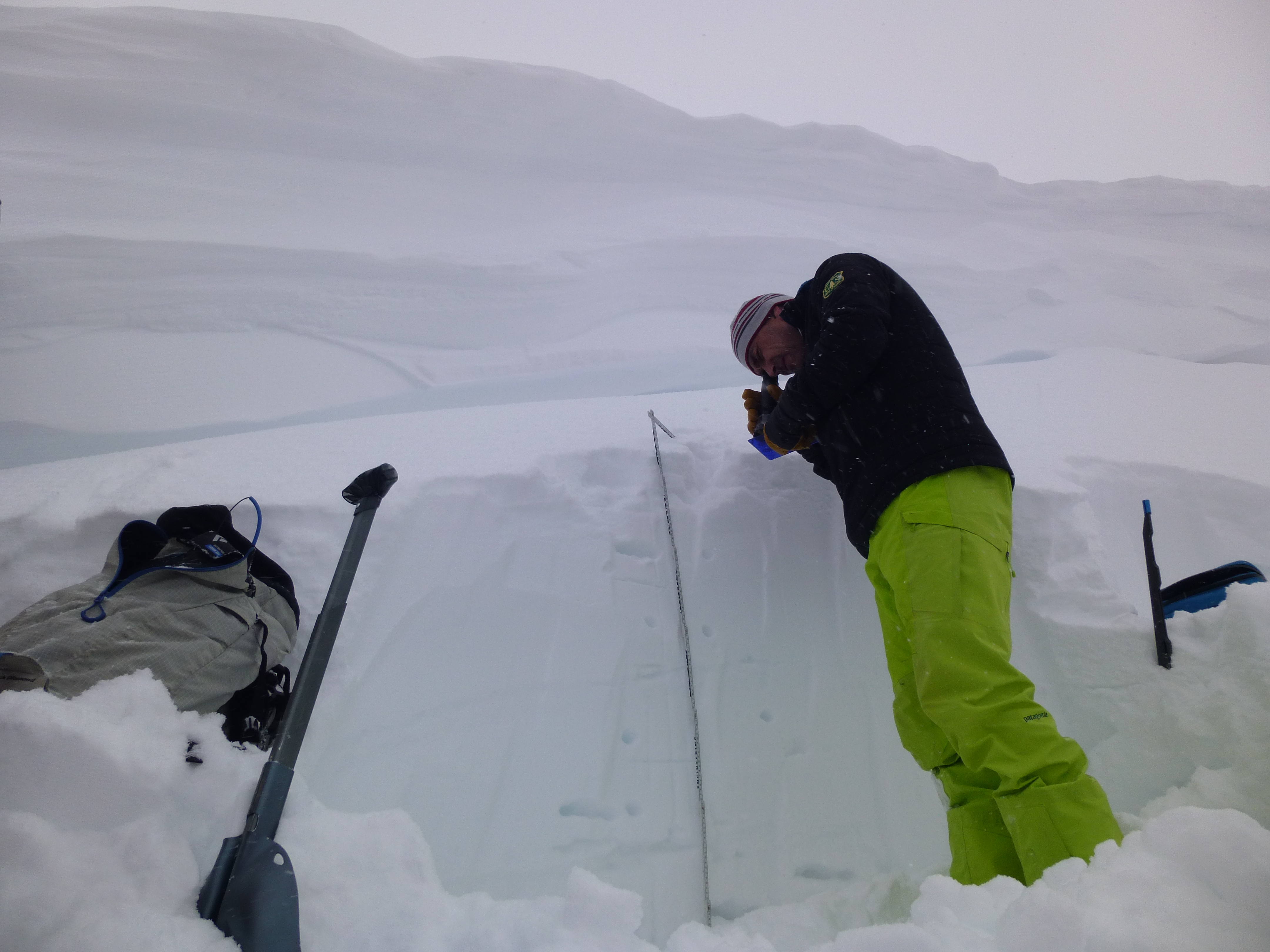 MSU snow science professor Jordy Hendrikx evaluates conditions in a snow pit dug beneath the cornice near the avalanche site.