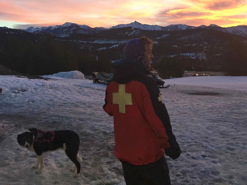 Race co-director Casey Heerdt and Kriby the avalanche rescue dog take in the sunrise prior to race start. PHOTO BY AMANDA EGGERT