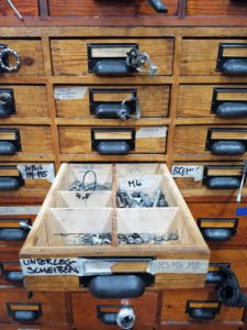 To overcome labeling problems that arise from the language barriers within the workshop, Rückenwind volunteers attached example bike parts to the drawers where parts are stored.