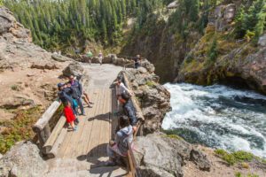 Visitors enjoy the view from Brink of the Upper Falls Overlook in the Grand Canyon of the Yellowstone River. NPS PHOTO