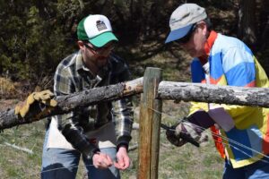 Robb Krehbiel of the National Parks Conservation Association works with a volunteer to build a wildlife-friendly fence. PHOTO COURTESY OF NPCA 