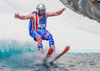 A skier donned in the American flag and a disco ball helmet skids across the pond at Big Sky Resort's 51st closing weekend. PHOTO BY CARLI JOHNSON