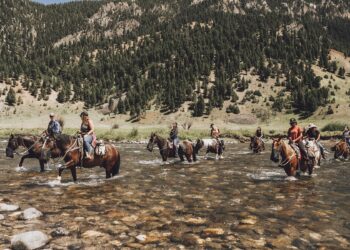 Program recipients ride horses in the Gallatin River near the site of the planned Big Sky Bravery Ranch. COURTESY OF BIG SKY BRAVERY