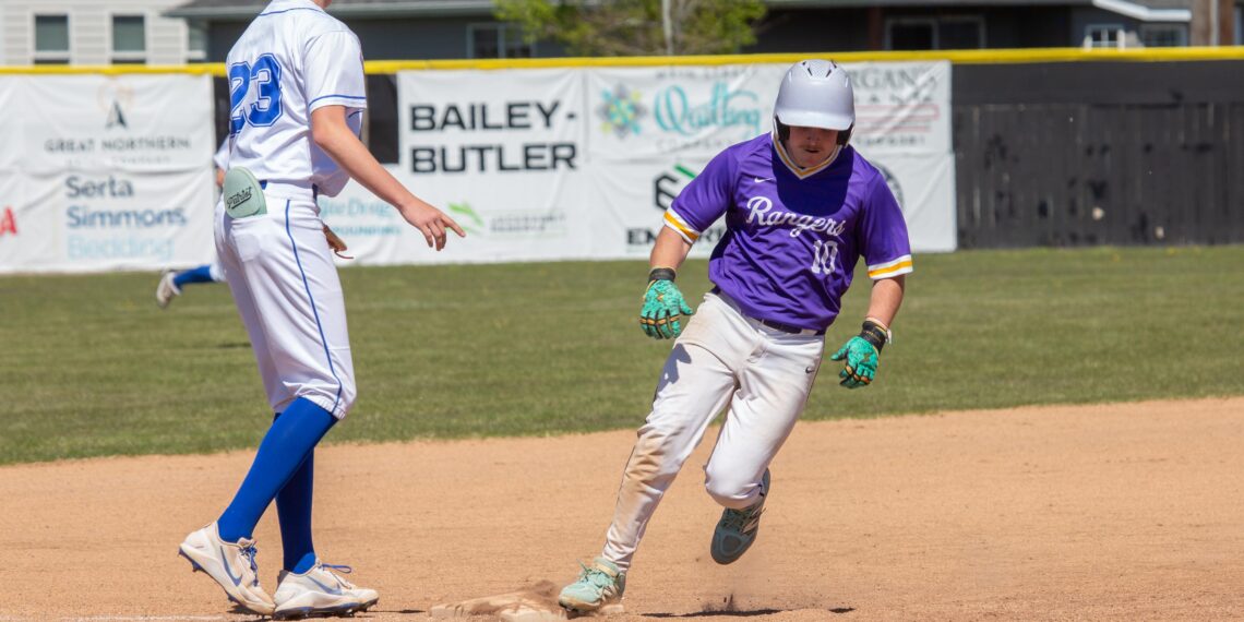 Two baseball players near a base: one in a white uniform with blue cap approaching a bag, the other in purple Rangers jersey sliding toward home plate.