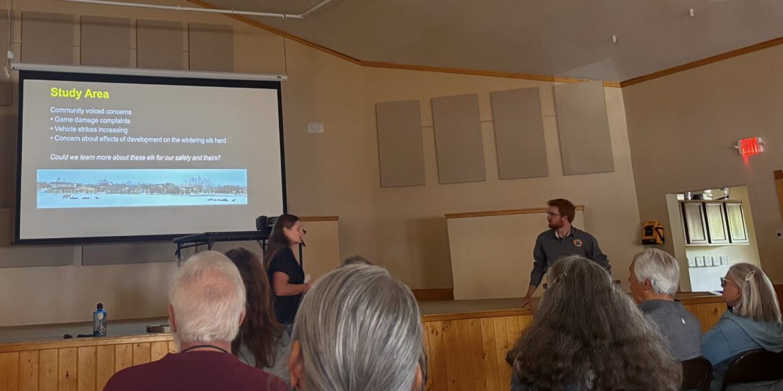 Presentation in a meeting hall: slide titled 'Study Area' with bullets on community concerns; two presenters stand near screen as audience listens.