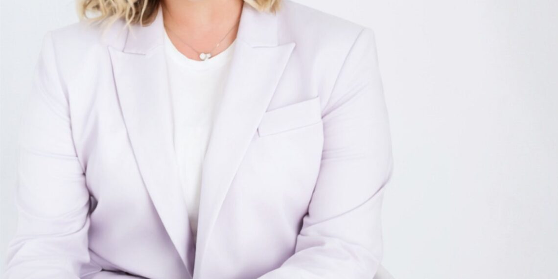 Professional portrait of a smiling woman in a pale blazer seated against a light background, with the Stone Leaf Financial logo visible to her right.