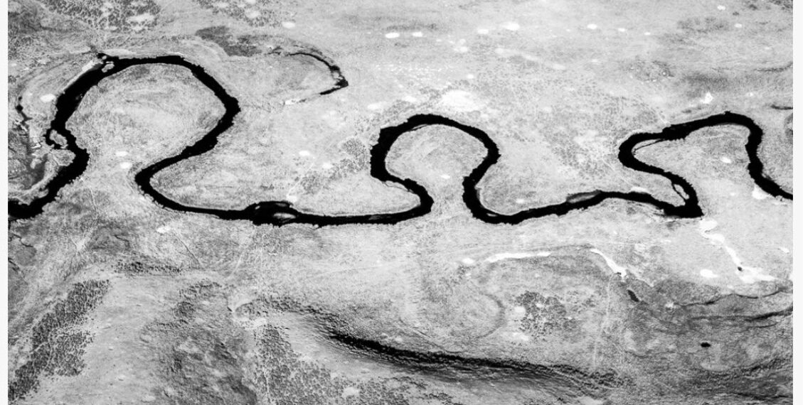 Black-and-white photo of a winding river cutting through rocky terrain; captioned Yellowstone Stream I