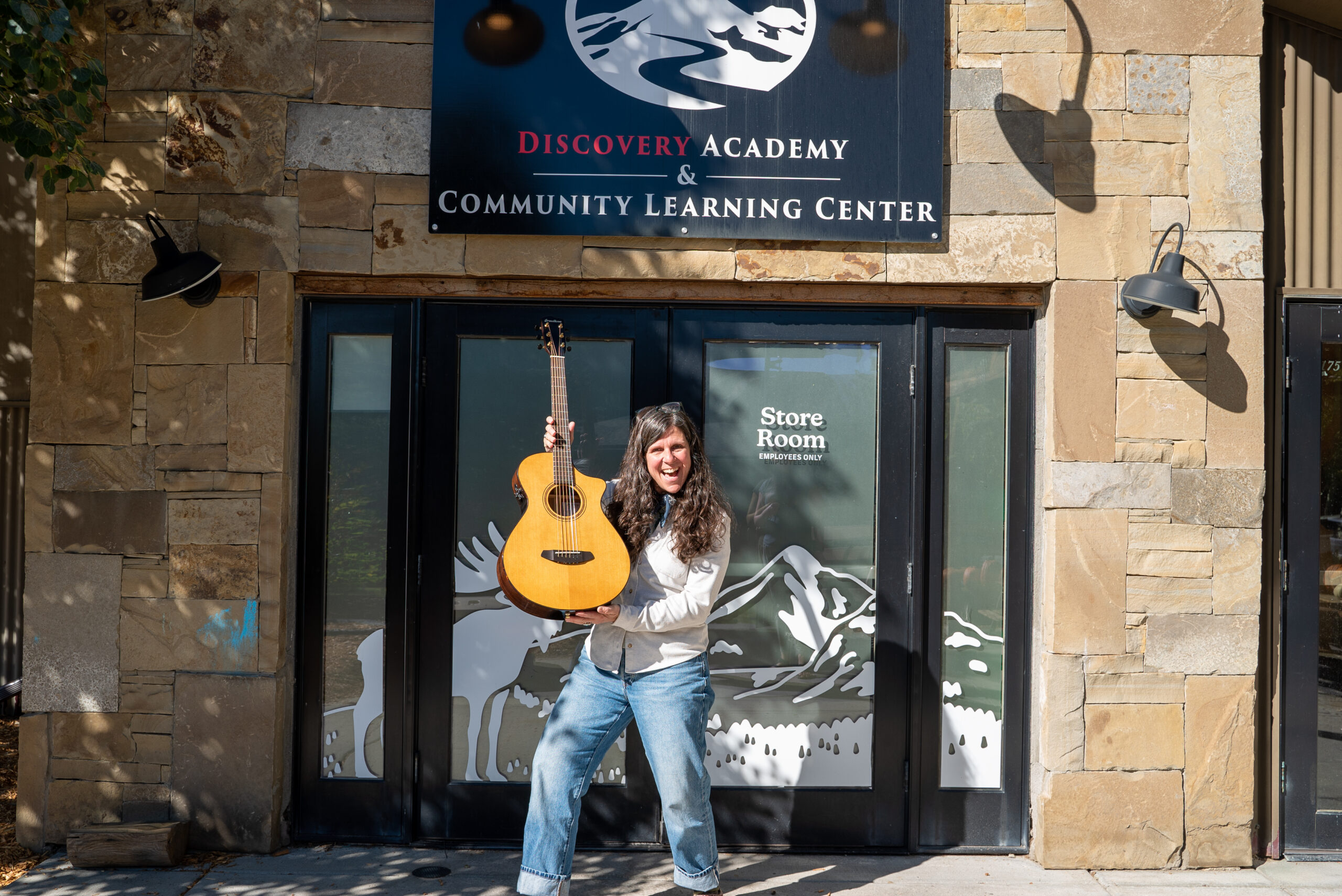 Julie Edwards, interim head of school/head of advancement at Discovery Academy, accepts a Breedlove Guitar. 